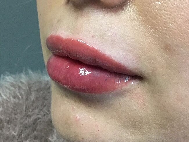 Close-up of glossy, tinted lips.