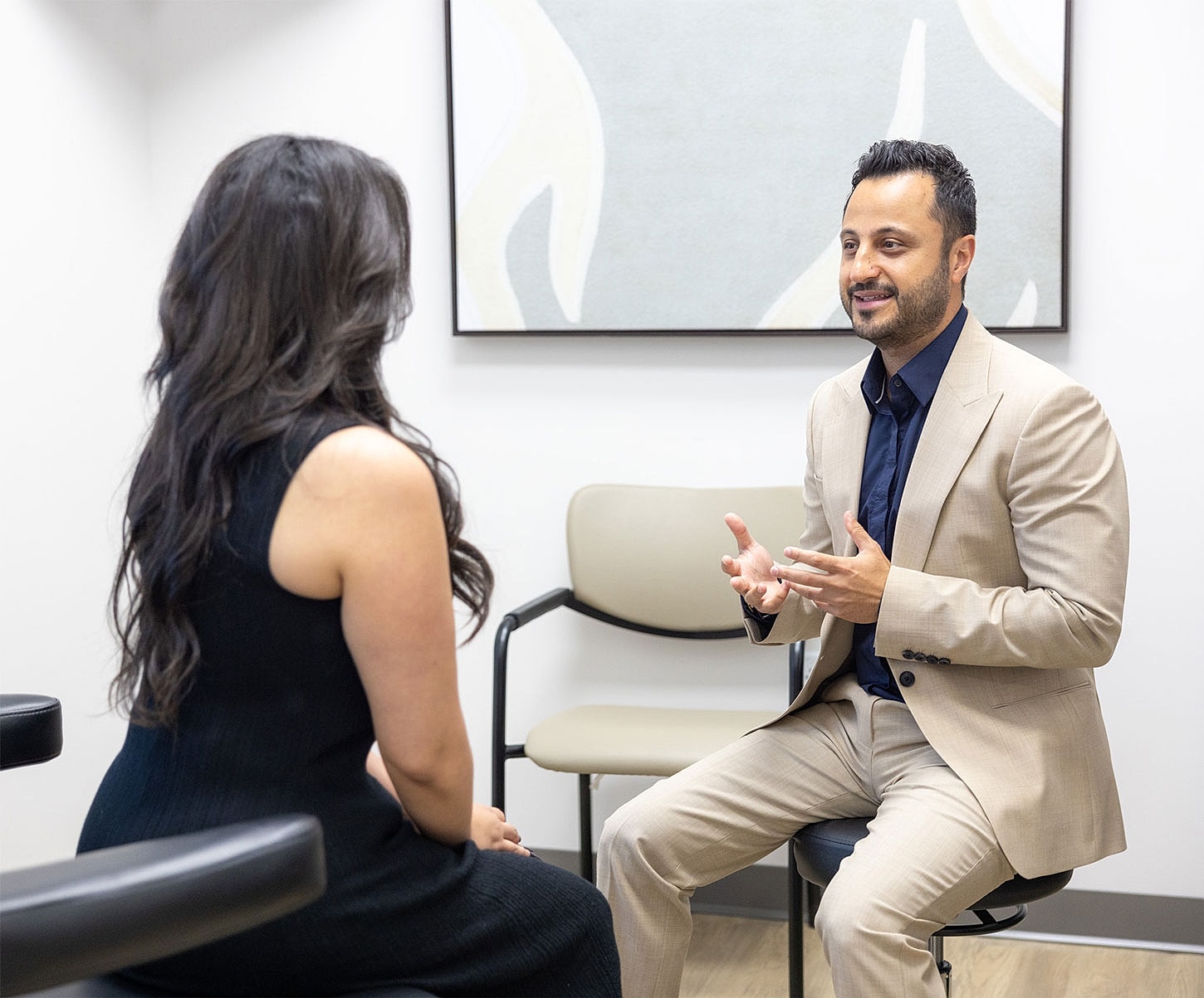 Man speaking to woman in an office setting.