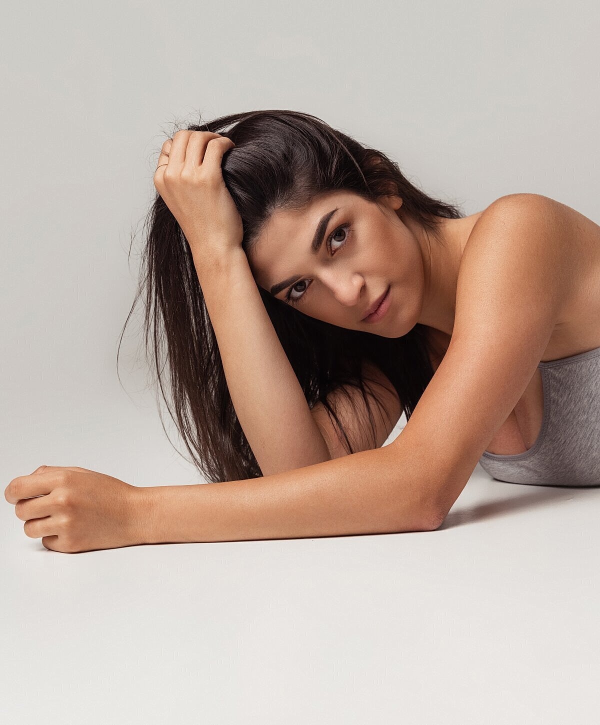 Model posing with long hair, lying down.