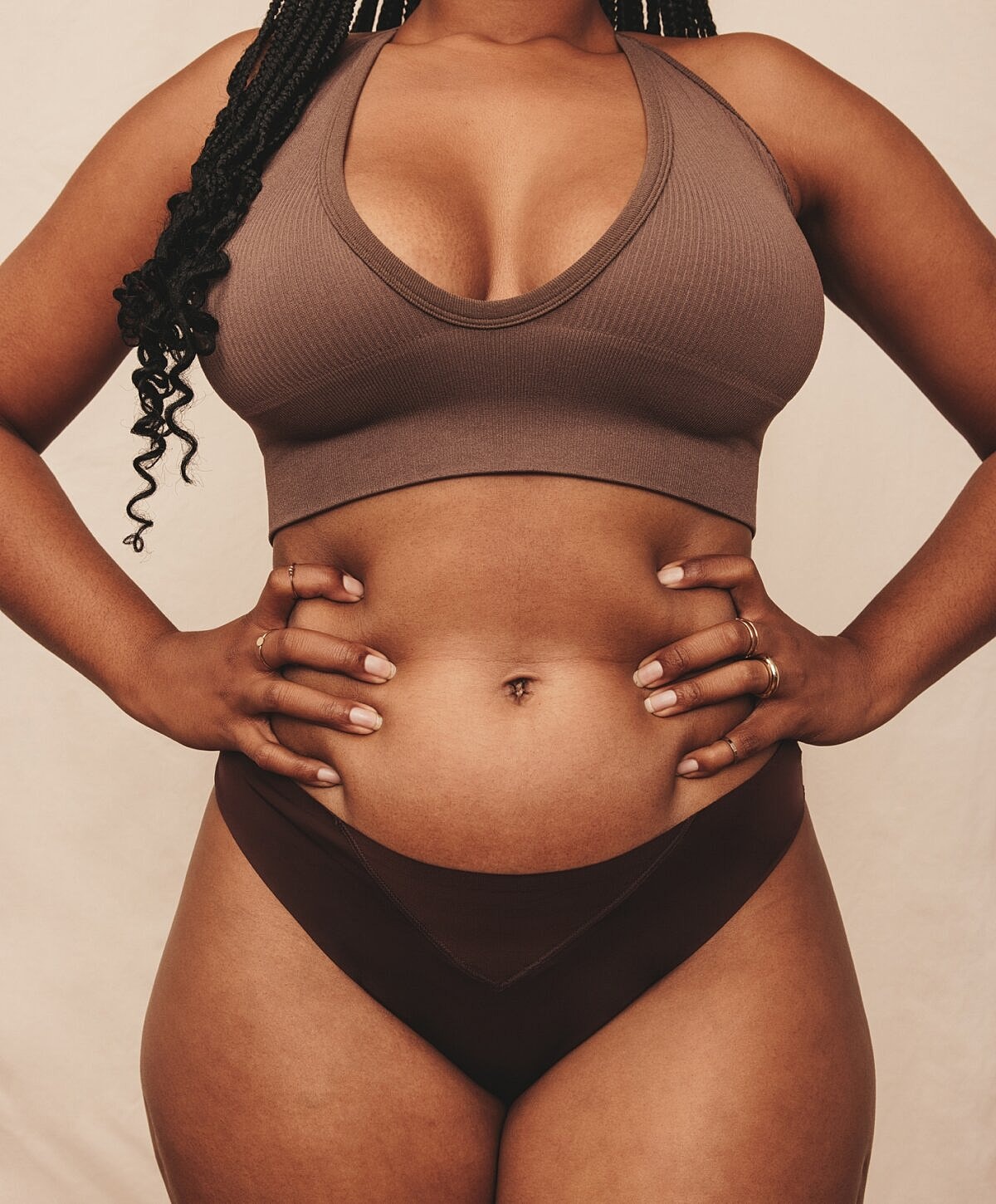 Woman in brown lingerie with hands on hips.