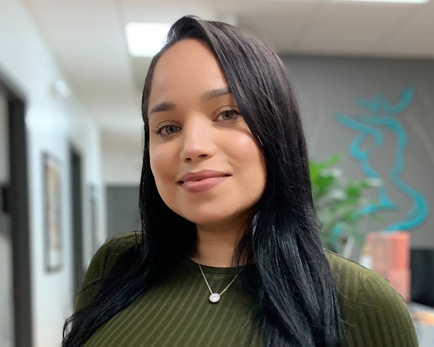 Woman smiling in an office setting.