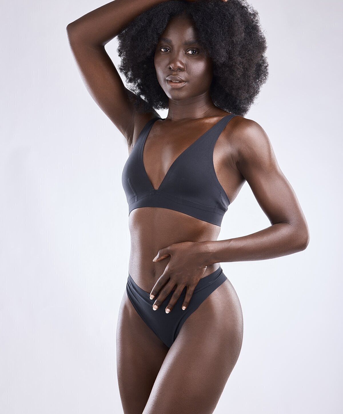 Model in black lingerie with natural hairstyle.