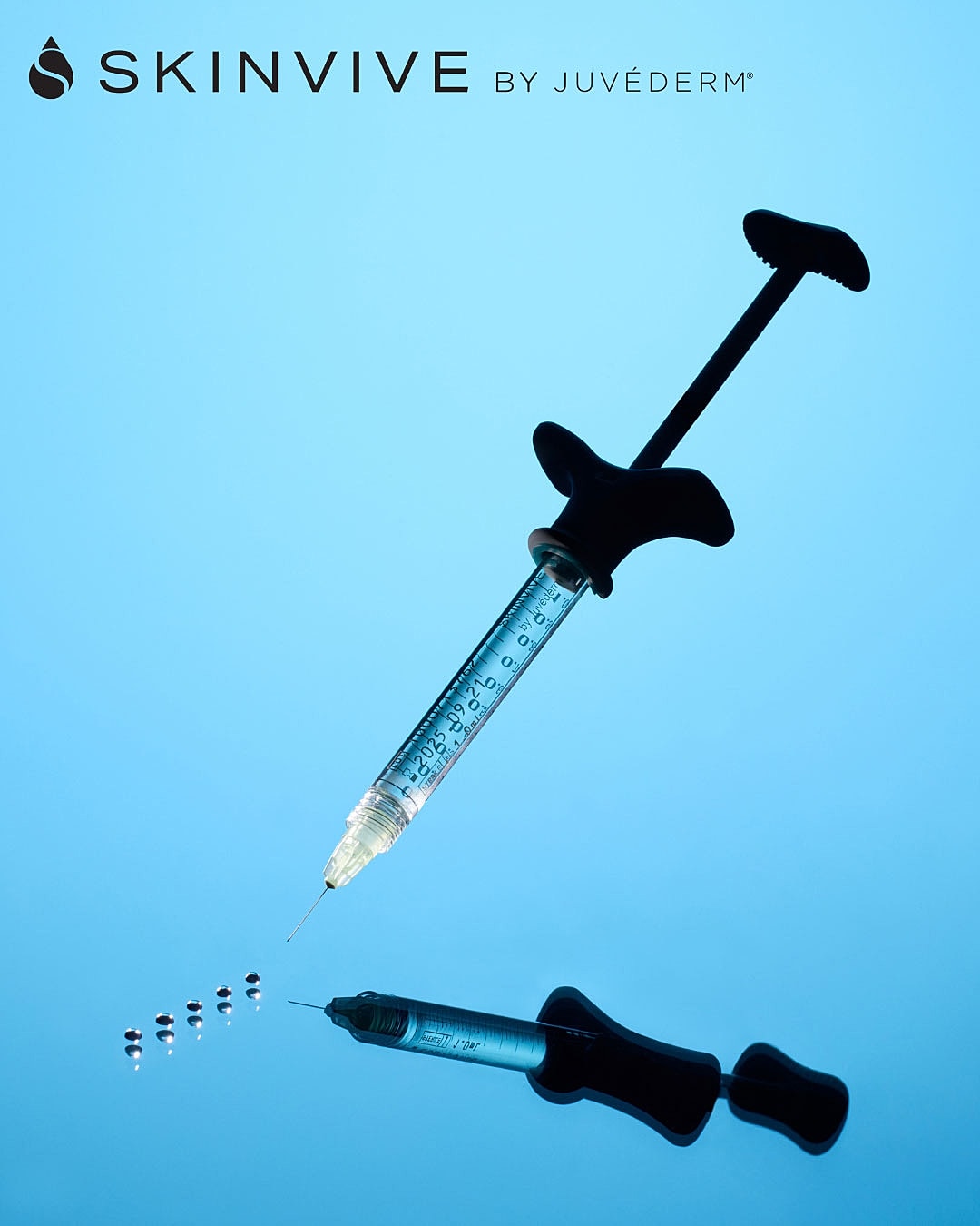 Syringe with cosmetic treatment reflection on blue background