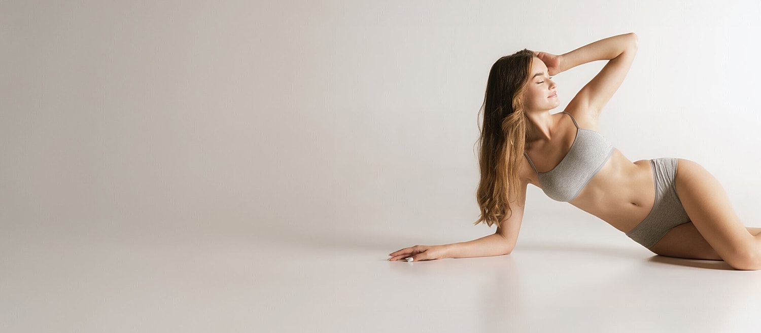 Model posing in gray lingerie on white background.