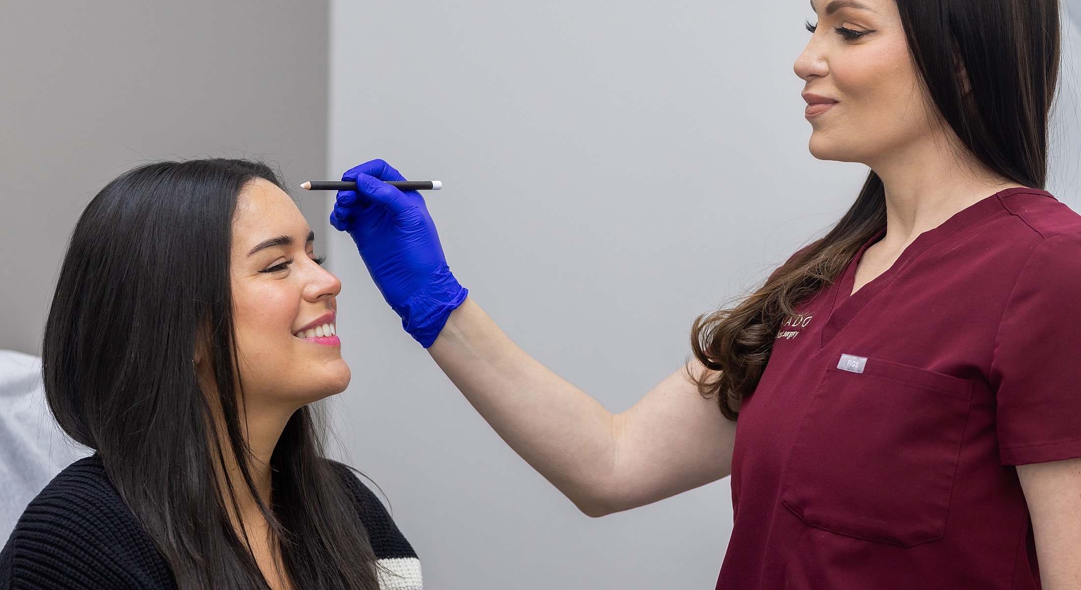 Woman receiving eyebrow shaping in a clinic.