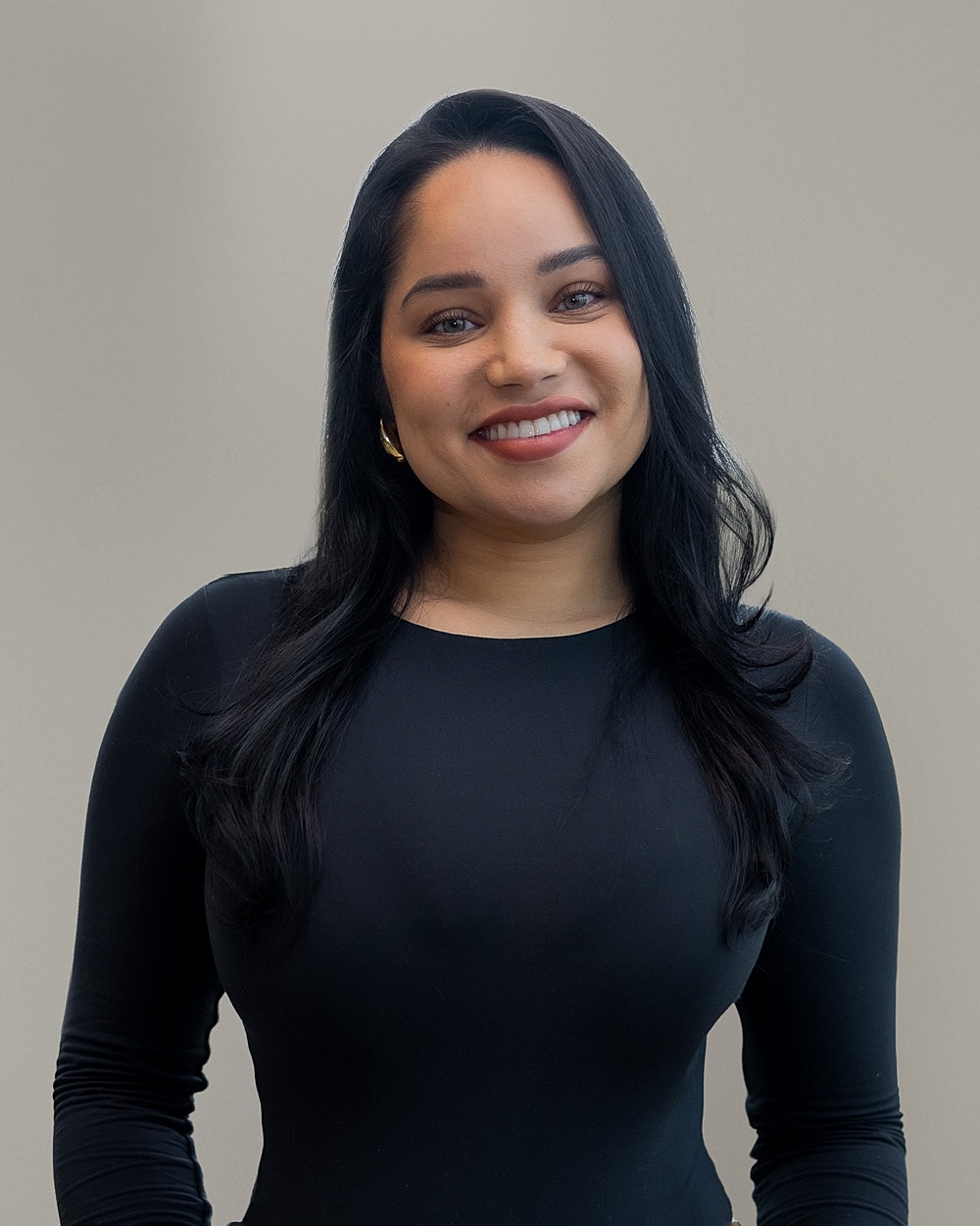 Woman smiling in a black long-sleeve top.