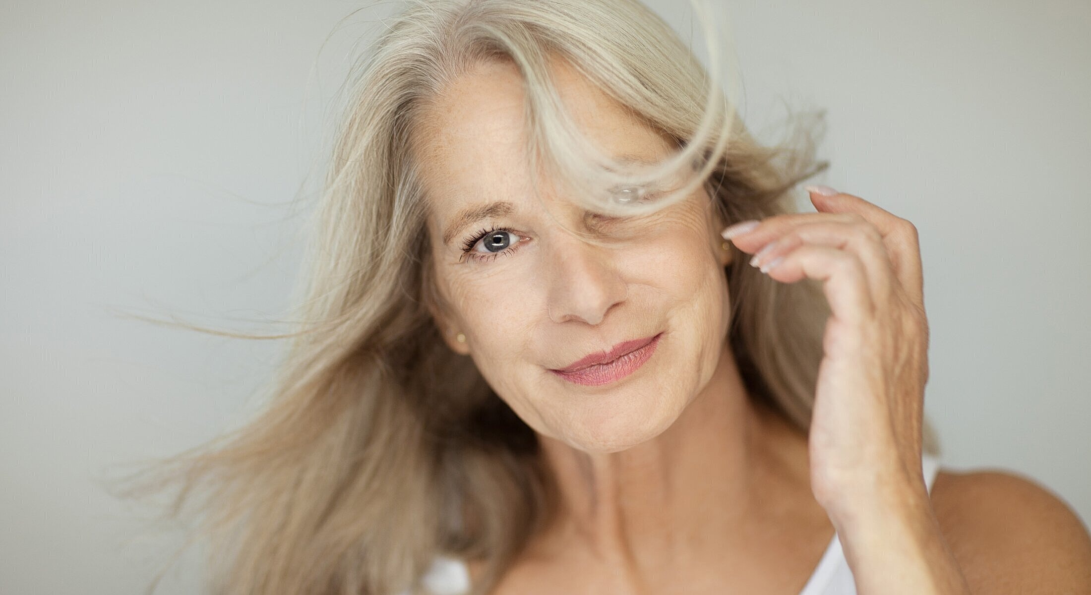 Smiling woman with flowing gray hair.