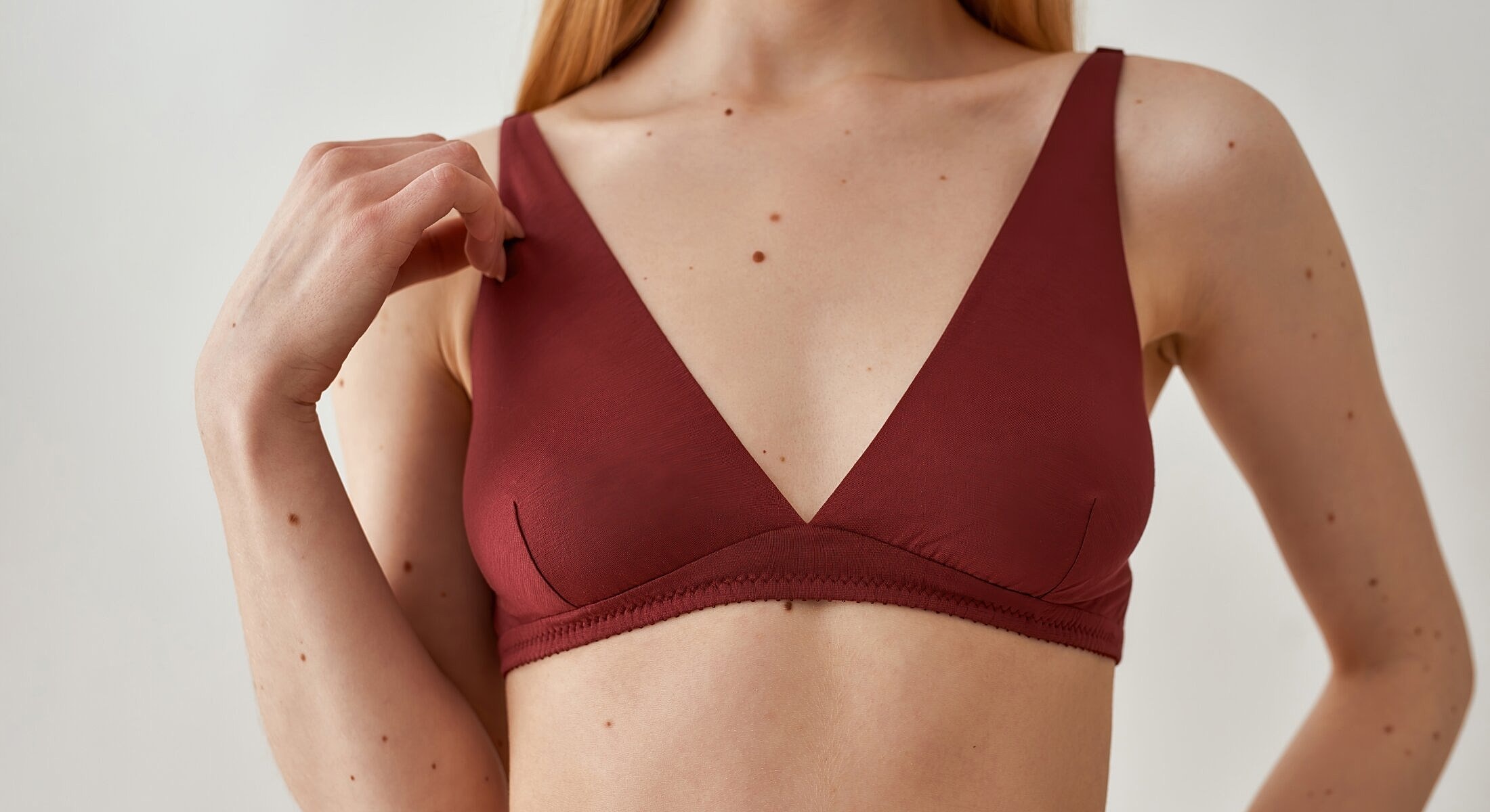 Model wearing a maroon bralette top.
