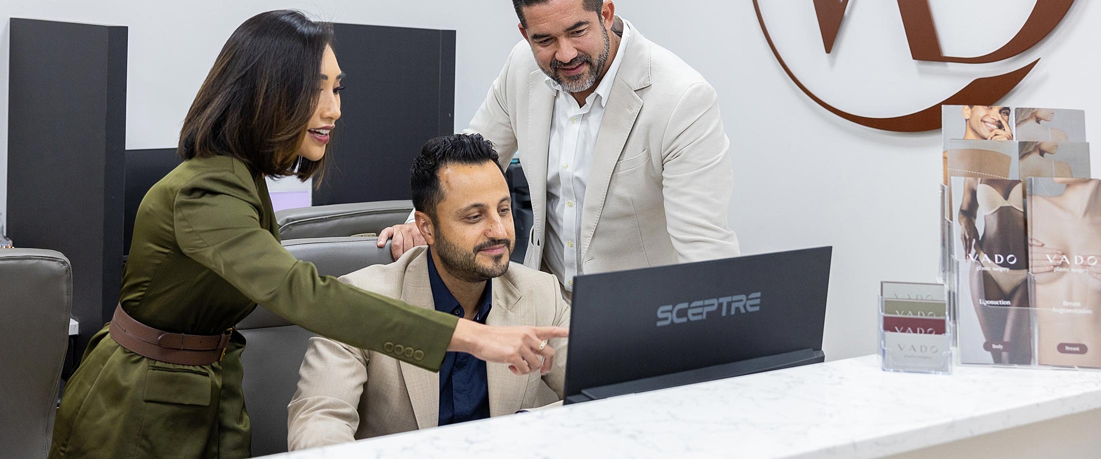 Team collaborating at a computer in an office.