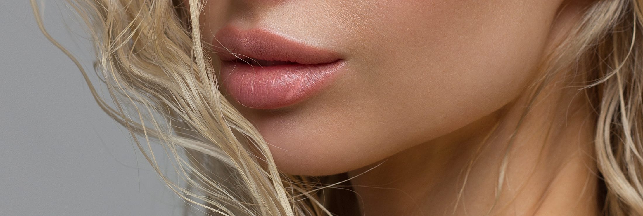 Close-up of lips and wavy blonde hair.