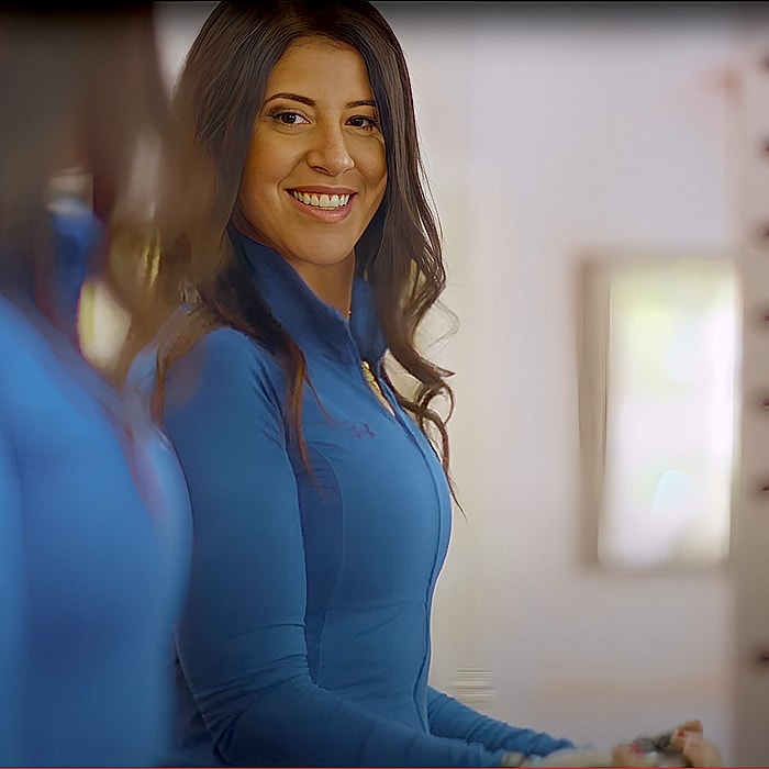 Smiling woman in blue athletic wear, looking back.