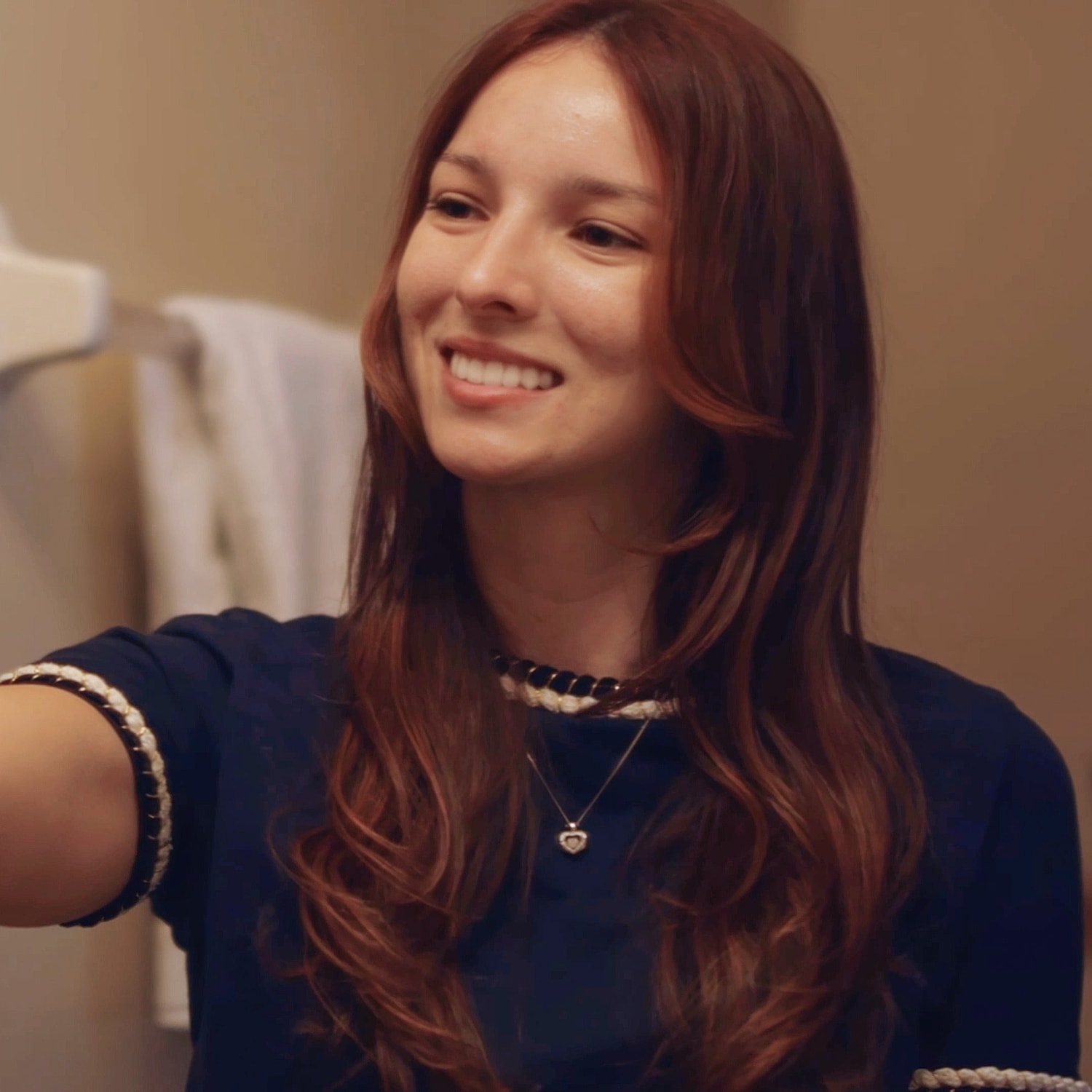 Woman smiling in a bathroom mirror.