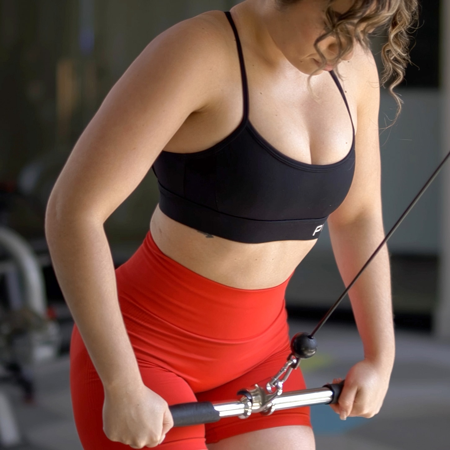 Woman exercising with cable machine in gym.