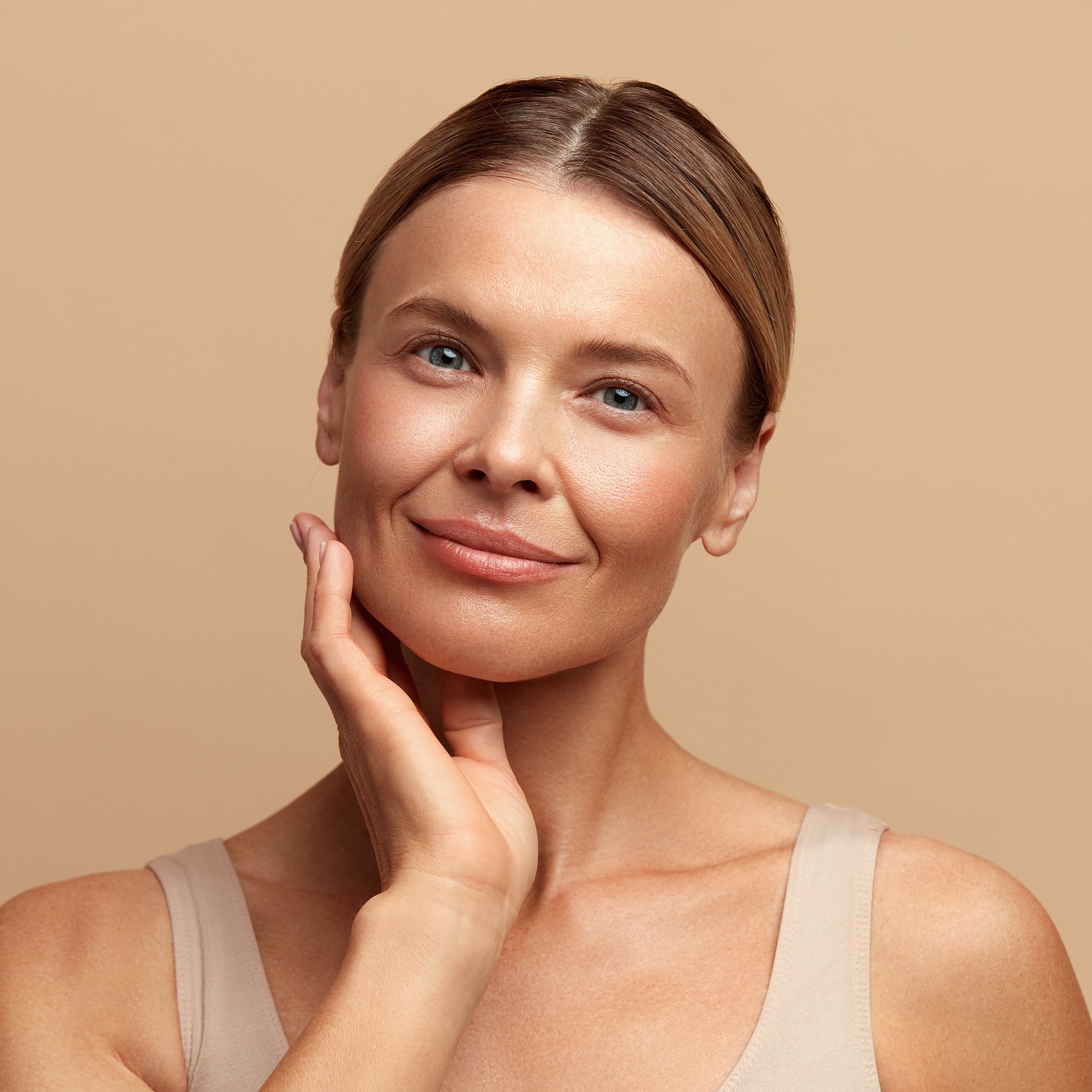 Smiling woman touching her face softly.